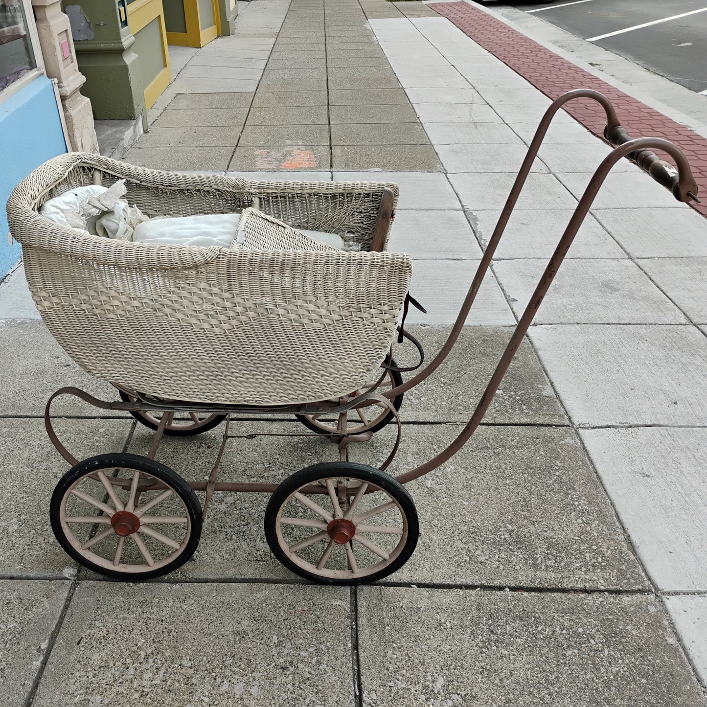 Vintage-style wicker baby buggy on a sidewalk