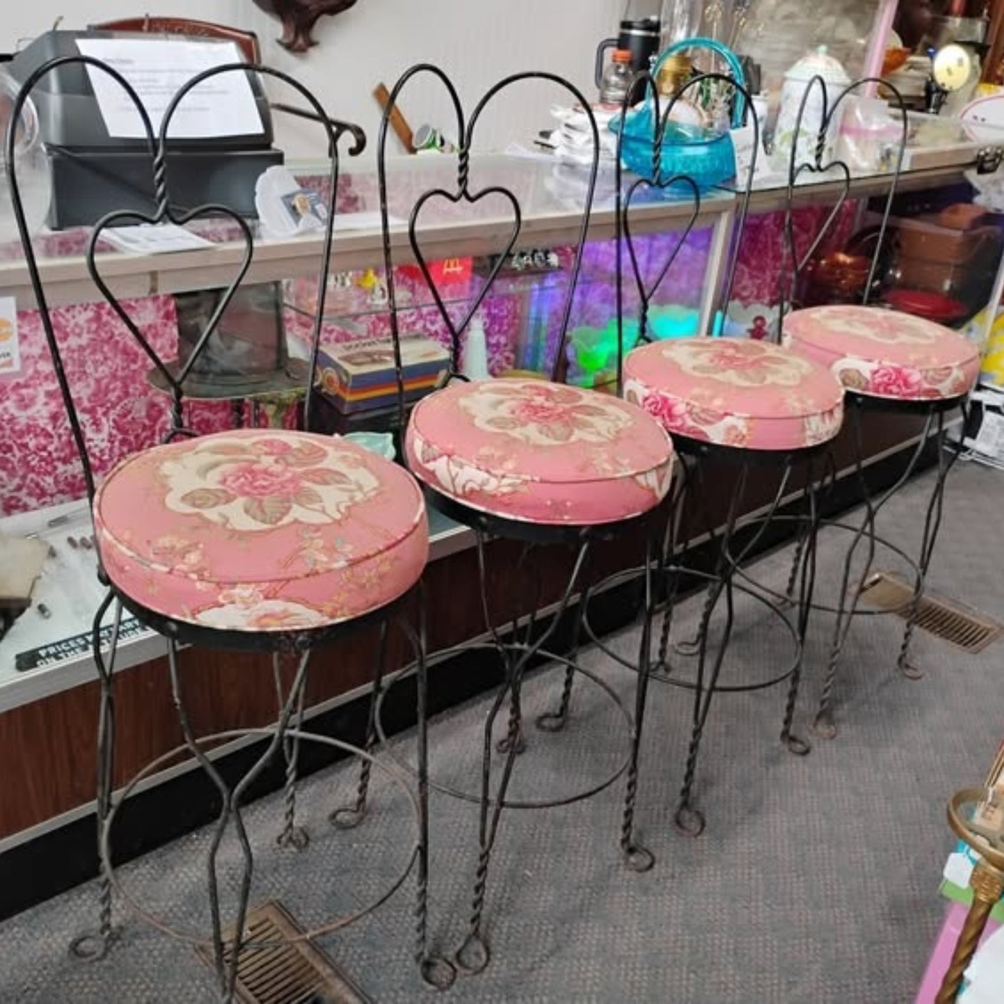 Set of vintage-style stools with floral cushions in a store setting